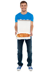 Image showing Casual guy showing freshly baked yummy pizza