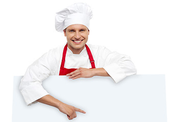 Image showing Handsome chef pointing at white billboard