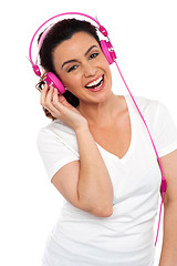 Image showing Young smiling woman listening to music