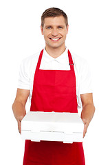 Image showing A chef in red uniform offering you a pizza box