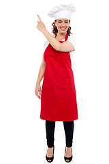 Image showing Full length portrait of female chef pointing away