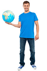 Image showing Trendy casual guy posing with a globe