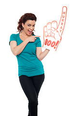 Image showing Young woman pointing at large foam hand