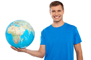 Image showing Attractive young man holding globe in his hand