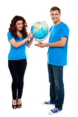 Image showing Full length of a couple holding globe over white