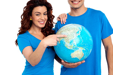 Image showing Woman pointing at China on globe while man holds it