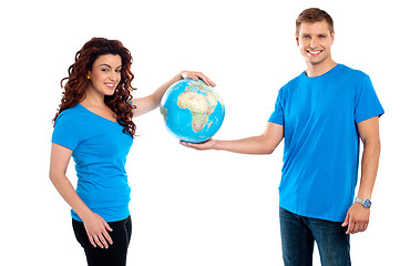 Image showing Attractive young couple holding a globe together