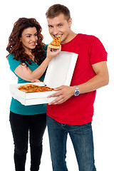 Image showing Caring girlfriend making her boyfriend eat pizza