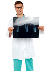 Image showing Happy young surgeon showing x-ray of a patient