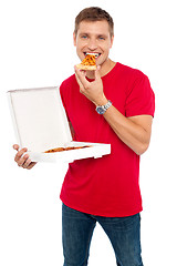 Image showing Cool young guy enjoying pizza
