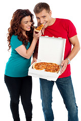 Image showing Girl sharing a pizza piece with her boyfriend