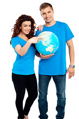 Image showing Couple posing for a picture with globe in hand