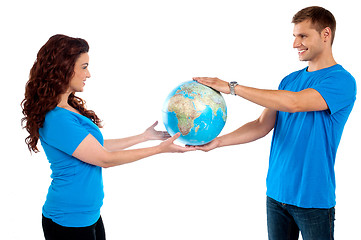 Image showing Causal young couple holding globe together