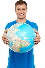 Image showing Casual young guy presenting globe