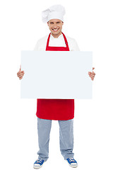 Image showing Chef holding blank white billboard. Full length shot
