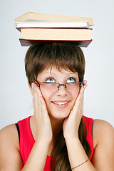 Image showing girl in glasses with books on head