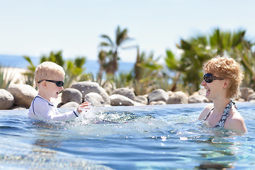 Image showing mother and son splashing