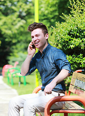 Image showing Happy young man in park with telephone