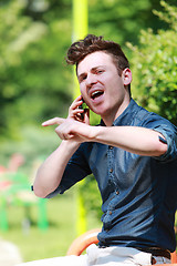 Image showing Young man in the park talk on telephone