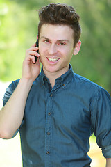 Image showing Portrait of handsome man with telephone in park