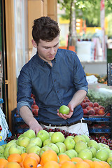 Image showing Young customer choosing fruits at grocery