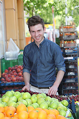 Image showing Smiling customer buying fruits at grocery