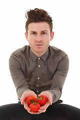 Image showing Young man offering tomatoes