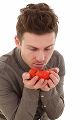 Image showing Young man smelling organic tomatoes