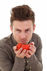 Image showing Young man smelling tomatoes