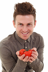 Image showing Young man offering tomatoes