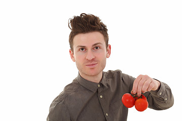 Image showing Portrait of young man holding tomatoes