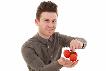 Image showing Young man smiling with tomatoes