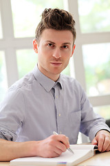 Image showing Young adult man writing note