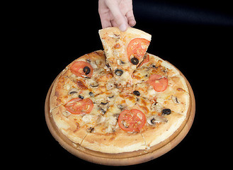 Image showing Pizza and slice of pizza in hand