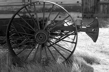 Image showing Black and White image of an old weathered wagon with rusted whee