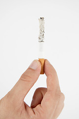 Image showing Hand, holding burning cigarette on white background