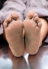 Image showing Sandy feet of a children on a play toy of a playground