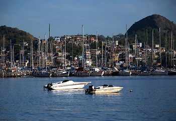 Image showing Slum near the sea, with rich boats and yachts in front