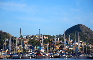 Image showing Slum near the sea, with rich boats and yachts in front