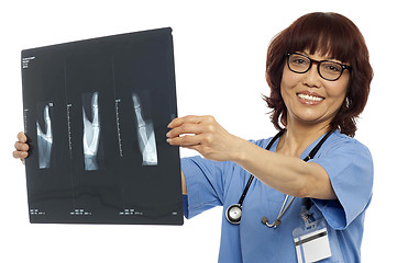 Image showing Doctor holding x-ray report. Analyzing it