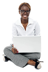 Image showing Corporate lady seated on floor working on laptop