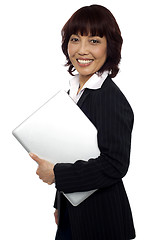 Image showing Asian corporate female holding laptop
