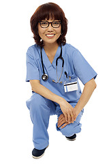 Image showing Female surgeon semi seated on floor. Studio shot