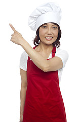 Image showing Female chef in uniform pointing away. Copy space concept