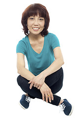 Image showing Casual teen girl sitting criss cross on the floor