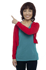 Image showing Asian model pointing at the copy space area