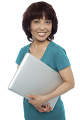 Image showing Casual woman carrying her laptop