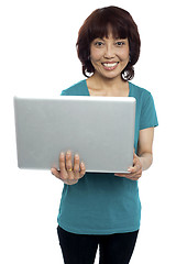 Image showing Casual asian girl holding laptop