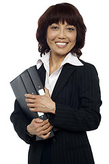 Image showing Smiling female executive holding binder