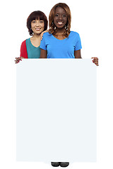 Image showing Casual girls standing behind blank whiteboard